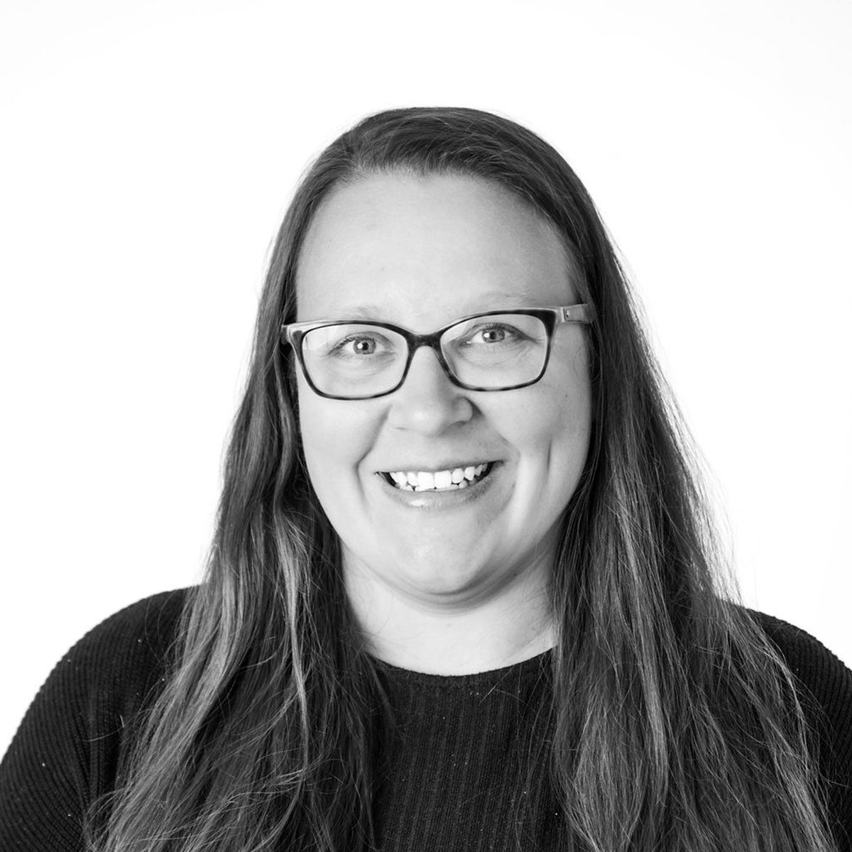 reized-rachel-buchholz Rachel Bucholz, Dir of Operations and paralegal at DLM law, with long hair and glasses smiles at the camera against a plain white background.